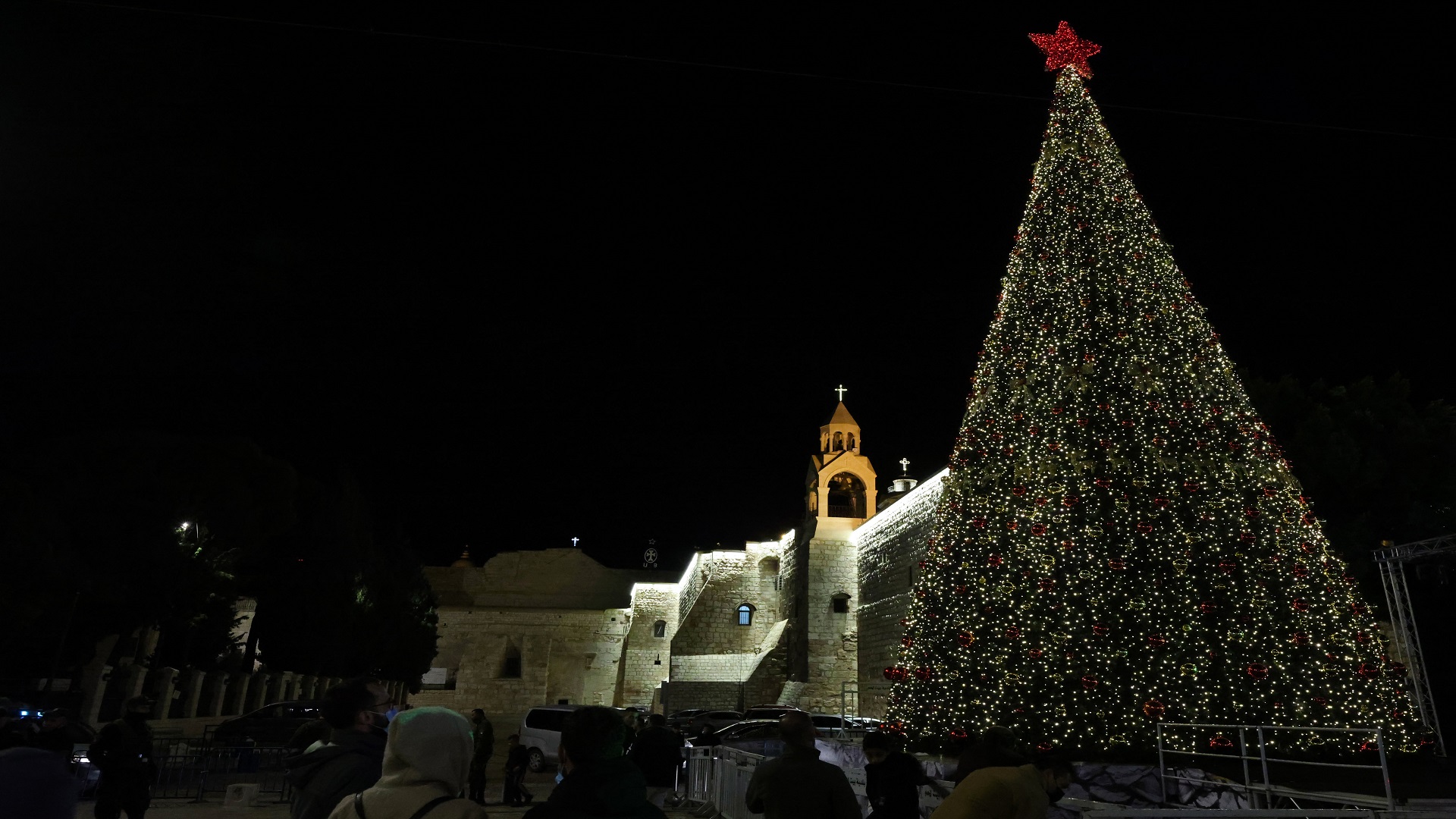 Image for the title: Bethlehem lights up Christmas tree as virus keep crowds away 