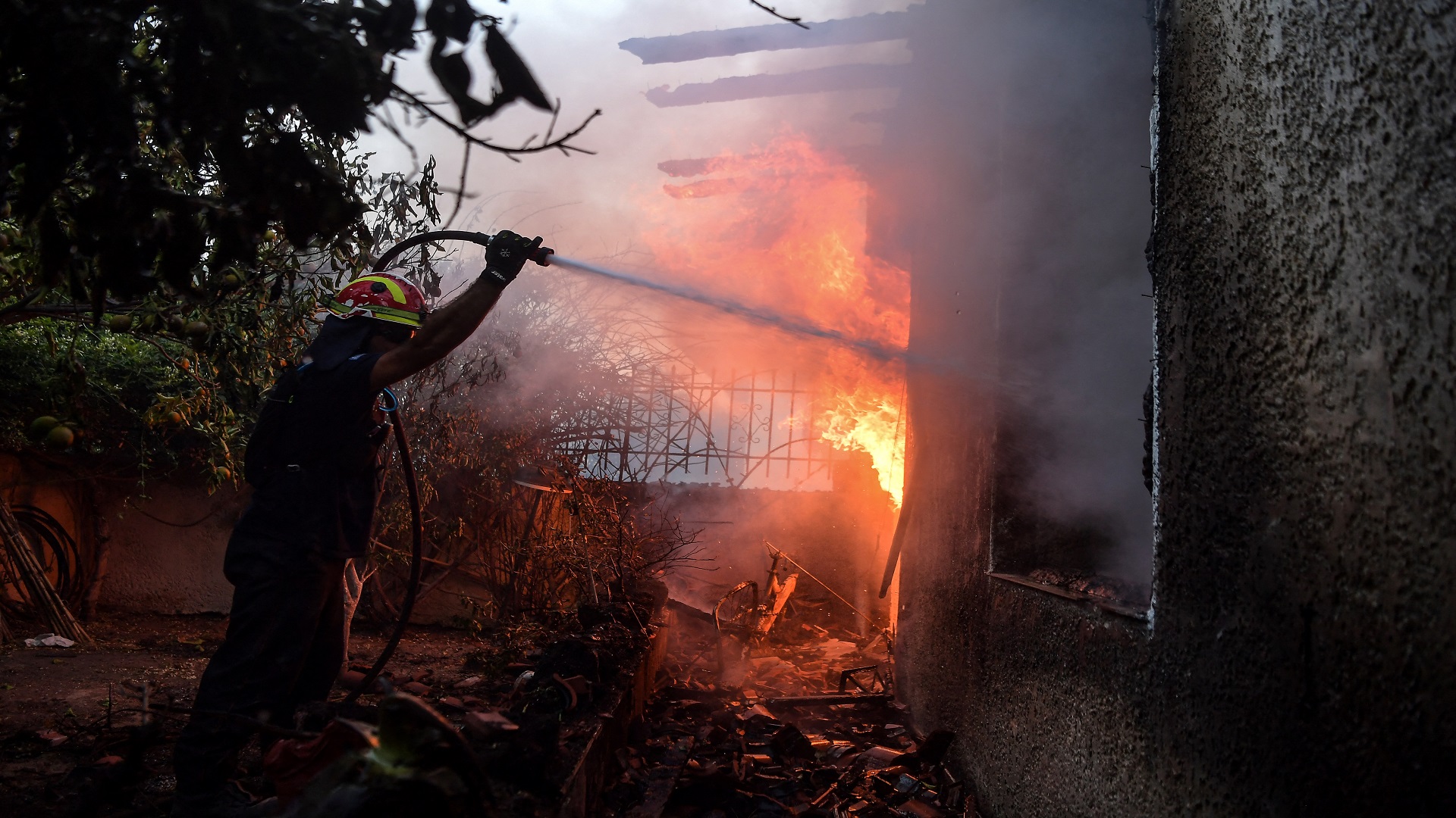 Image for the title: People flee homes as wildfire burns near Athens industrial zone 