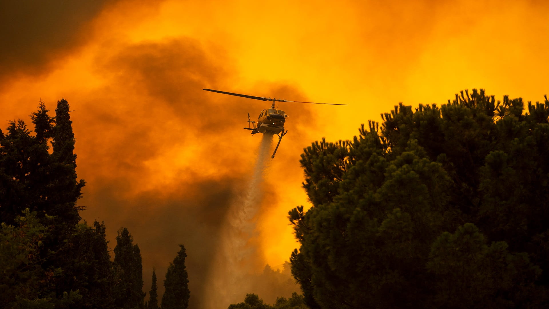 Image for the title: West Athens fire still burning but crews manage to save village 