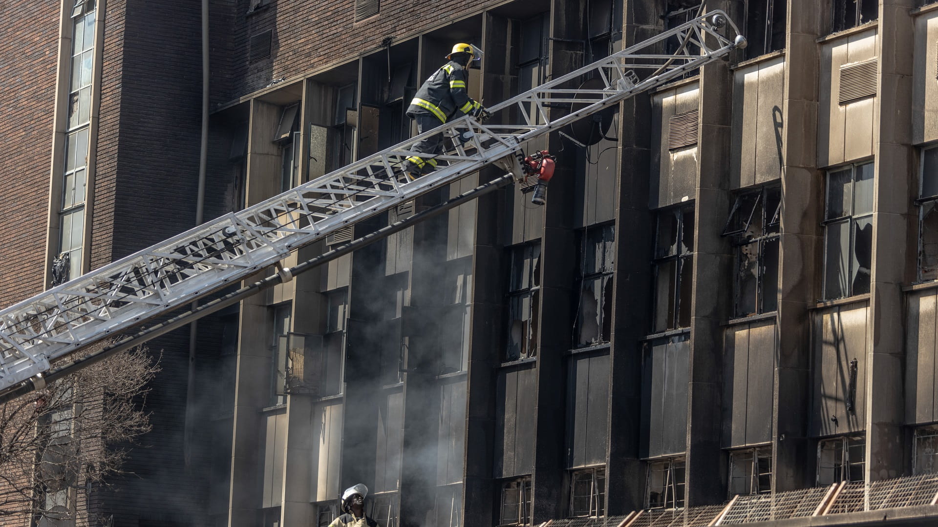 Image for the title: Fire engulfs illegal Johannesburg housing block, killing 73 