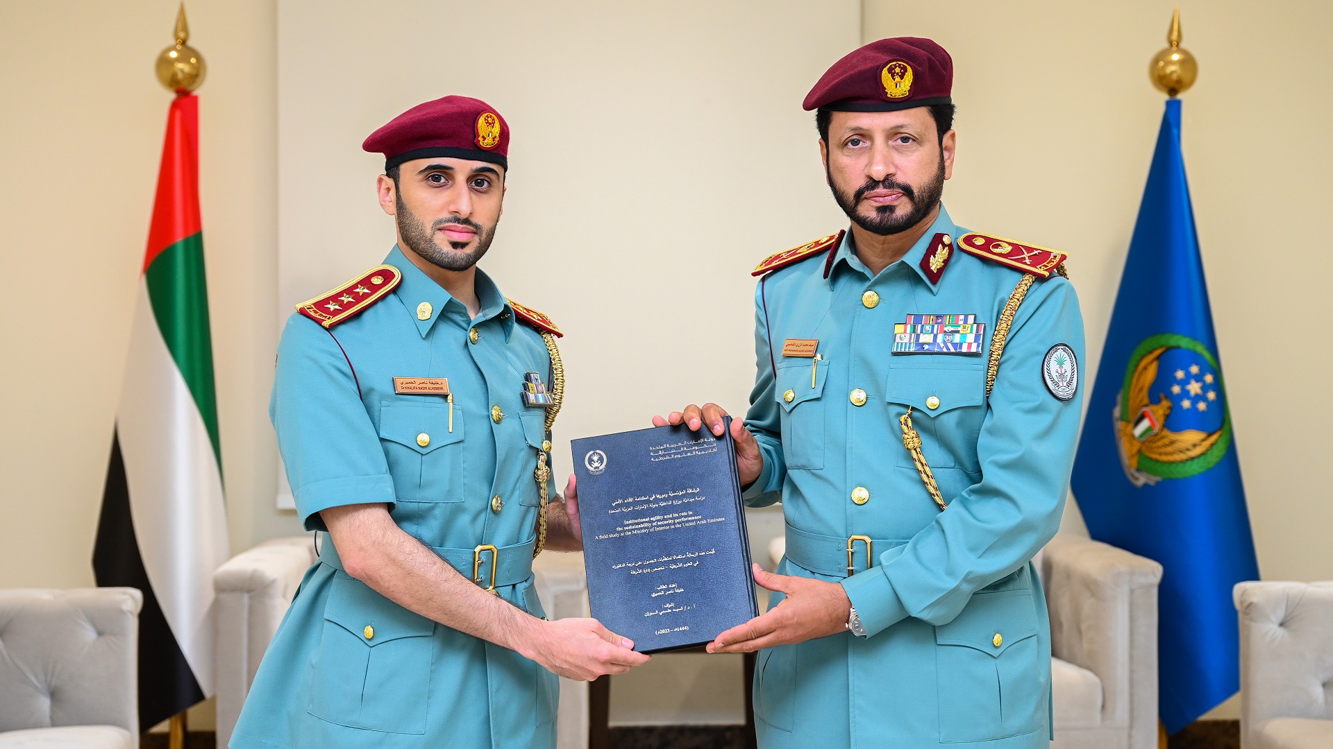 Image for the title: Al Shamsi congratulates an officer on obtaining Ph.D. degree 