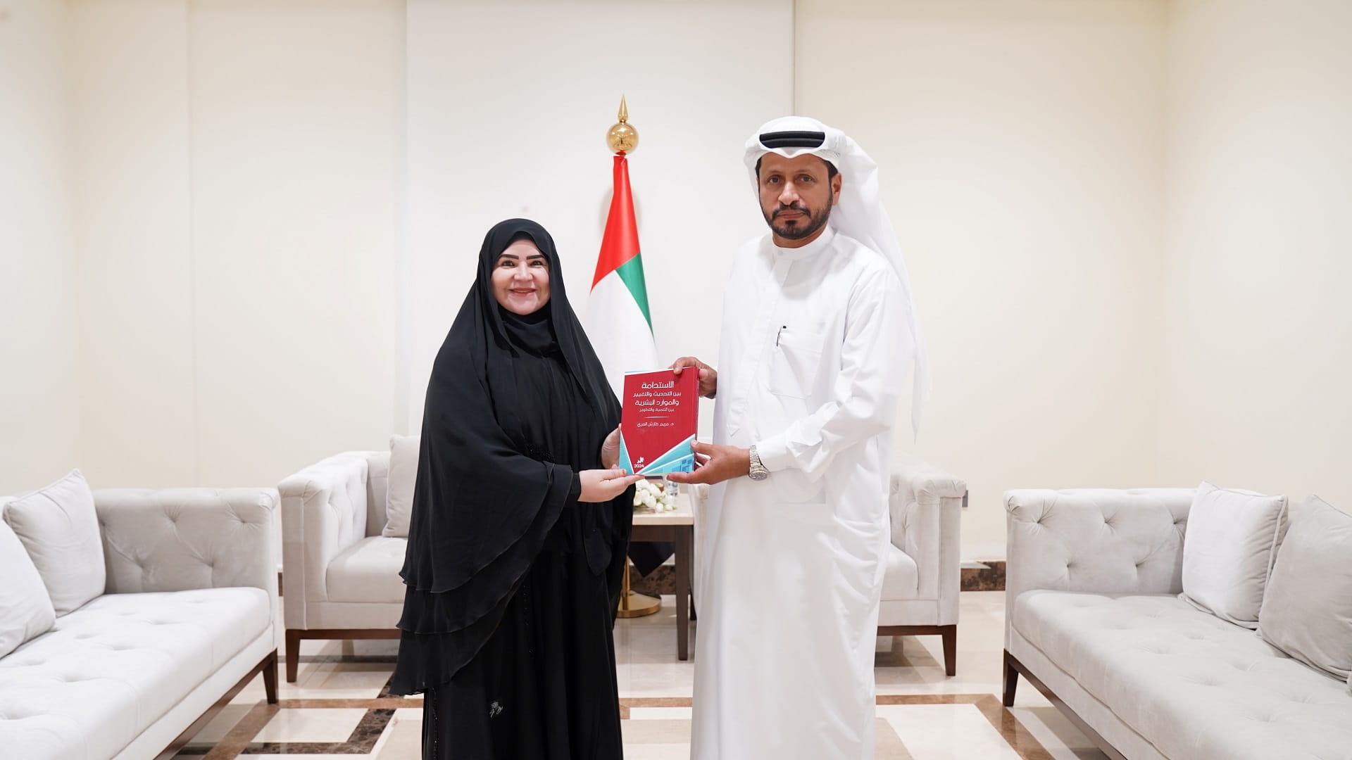 Image for the title: Al Shamsi receives a book on sustainability by Police staff 