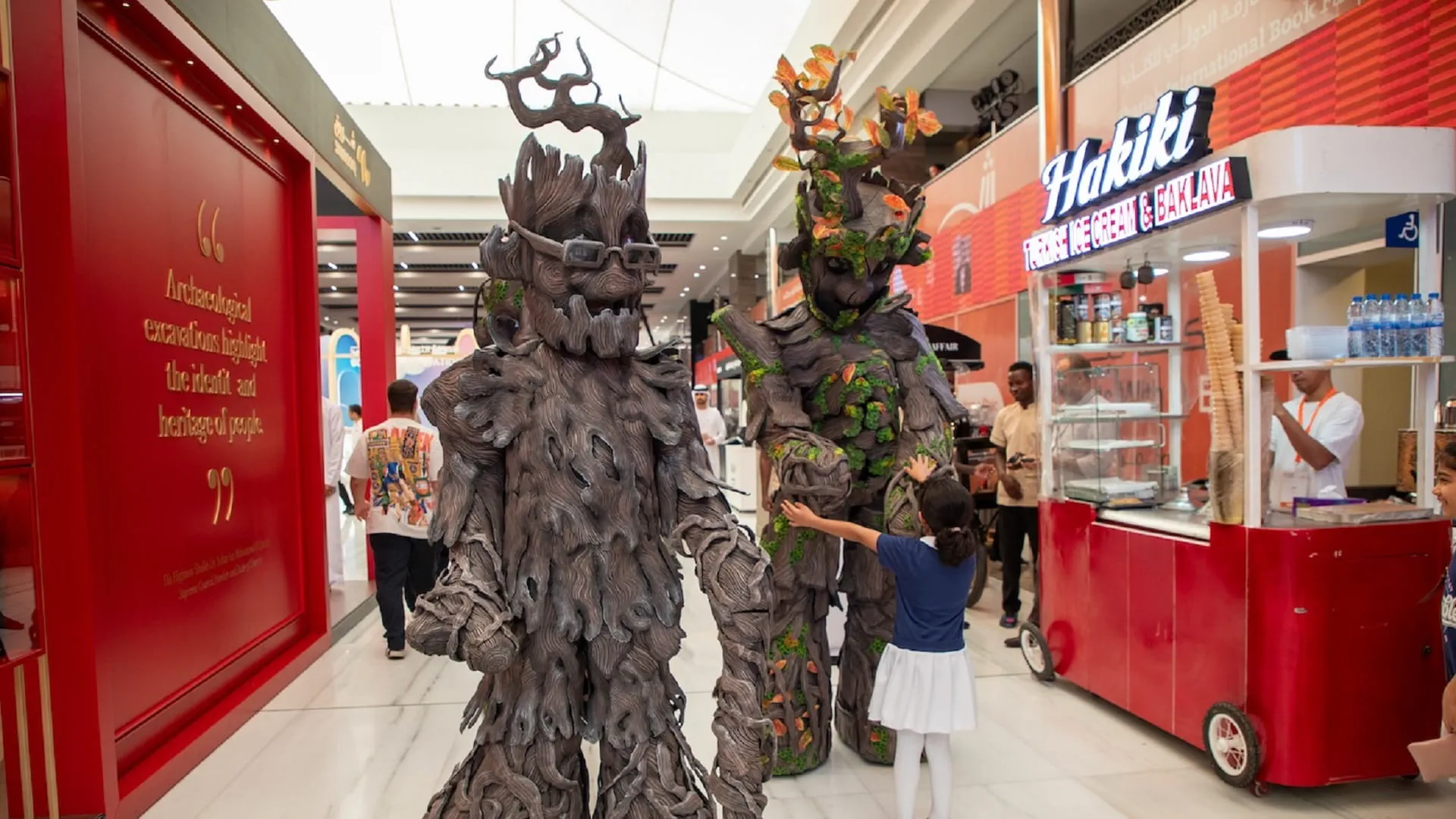 Image for the title: Seasons come alive on stilts at Sharjah International Book Fair 