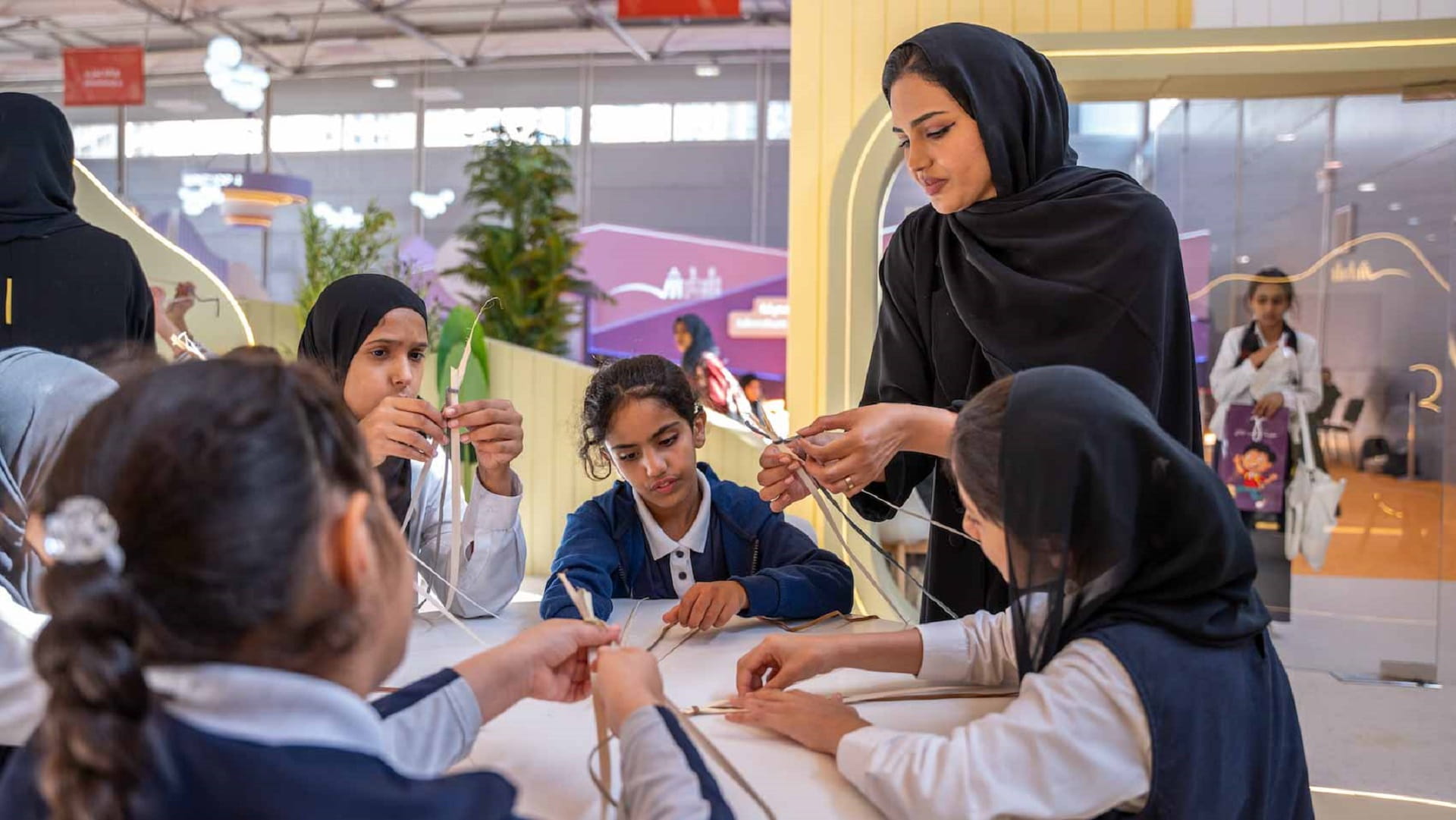 Image for the title: Children employ craft of Safeefah to design bookmarks at SIBF 