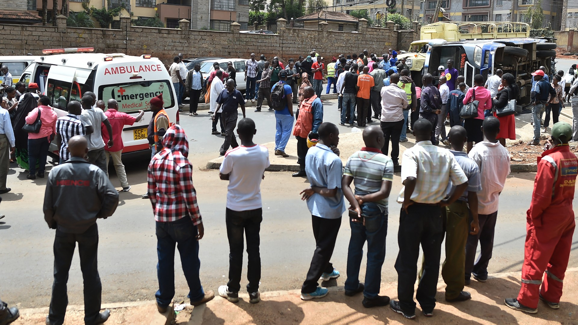 People watch at the scene of an accident between a bus and a lorry in Nairobi